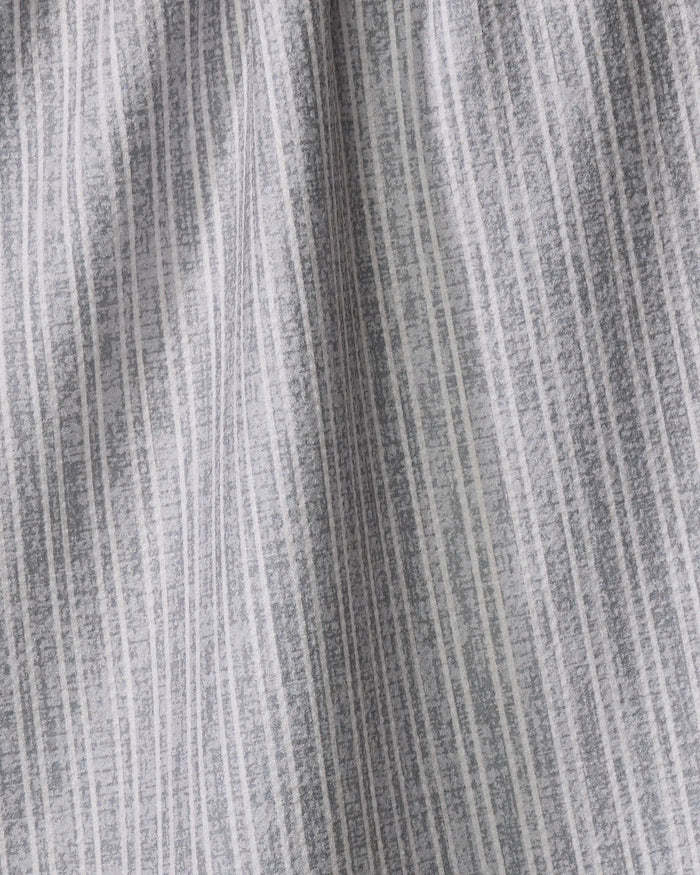 Close-up of the Garff Grey tea towel by Becki Owens, featuring light gray fabric with vertical white and dark gray irregular stripes, a textured pattern, soft folds, and a slightly crinkled appearance.