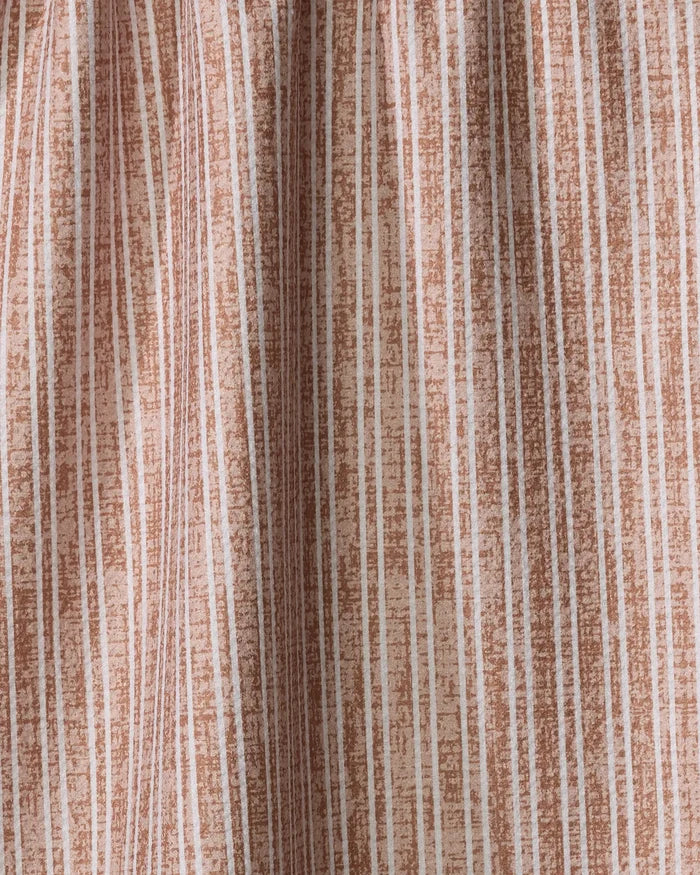 A close-up of the Garff Rust recycled kitchen towel by Becki Owens, showing its textured fabric with vertical light brown and white stripes and a subtle crinkled effect.