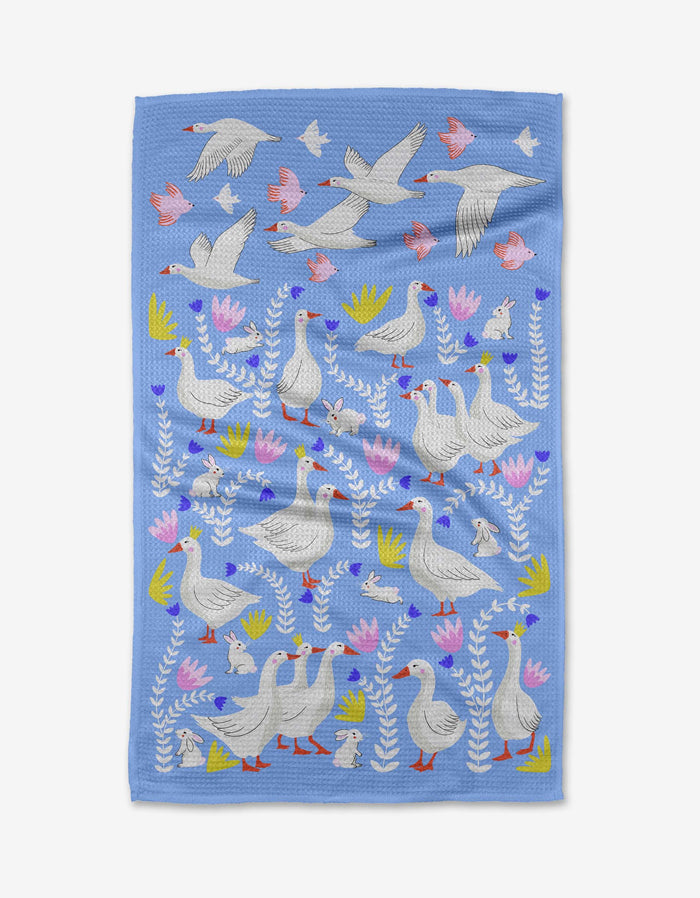 The Geese Bunnies tea towel by Ceyda Alasar is crafted from quick-drying recycled materials and decoratively features white geese, pink birds, flowers, and green leaves.