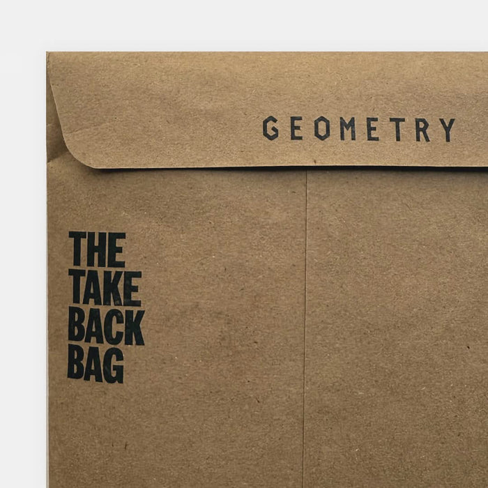 A brown paper envelope from GEOMETRY, called the Geometry Take Back Bag, features bold black text reading THE TAKE BACK BAG on the left and GEOMETRY near the top flap.