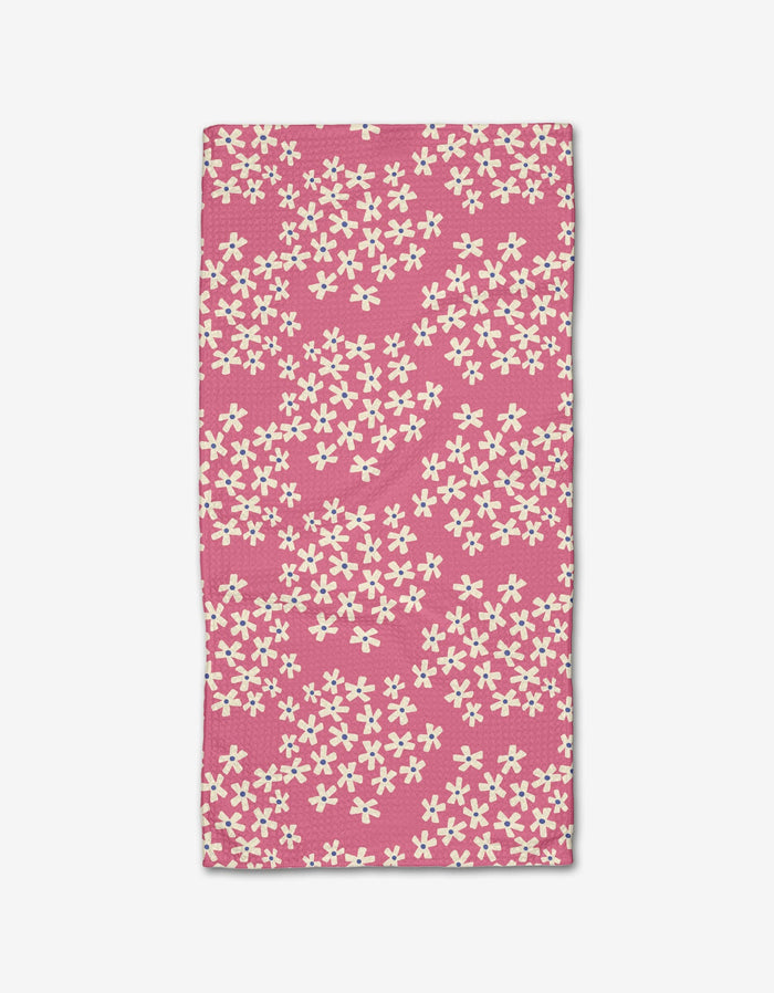 Lizzie Clark’s Geranium towel is a rectangular pink bar towel with scattered small white flowers, made from soft Geoweave fabric and shown flat on a white background.