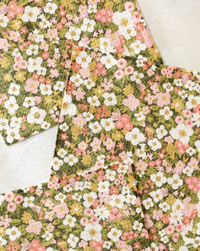 Four super-absorbent Gilded Garden dishtowels by Lisa Nelson feature a dense floral pattern of white, pink, and yellow blooms overlapping on a light marble surface.