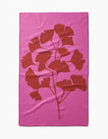 PrintedPlant’s Ginkgo blanket is pink and rectangular, with a bold red leafy branch silhouette in the center, made from ultra-absorbent Geoweave fabric for exceptional softness and durability.