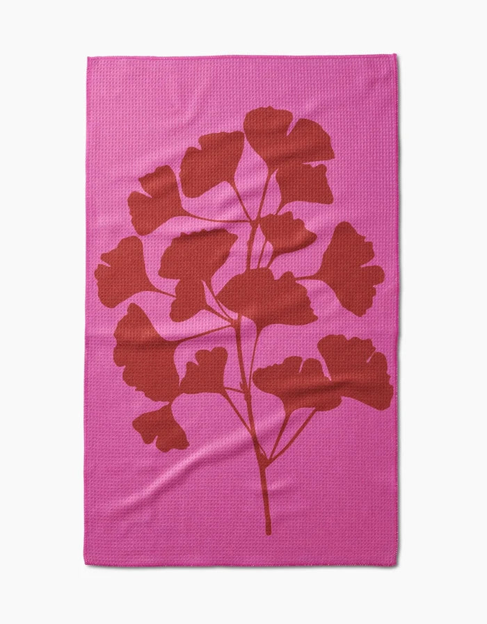 PrintedPlant’s Ginkgo blanket is pink and rectangular, with a bold red leafy branch silhouette in the center, made from ultra-absorbent Geoweave fabric for exceptional softness and durability.