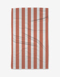 The BetterDays Glow Geoweave towel, made from ultra-absorbent recycled materials, features a simple rectangular design with vertical red and white stripes and visible creases.