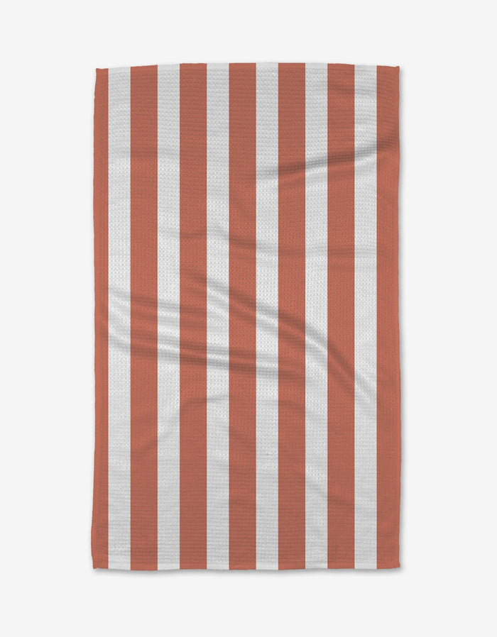 The BetterDays Glow Geoweave towel, made from ultra-absorbent recycled materials, features a simple rectangular design with vertical red and white stripes and visible creases.