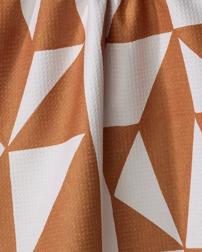 Close-up of Lisa Nelson’s Golden Angles kitchen towel, an eco-friendly design with textured fabric and a geometric pattern of large white triangles on a brown background, softly gathered at the top.