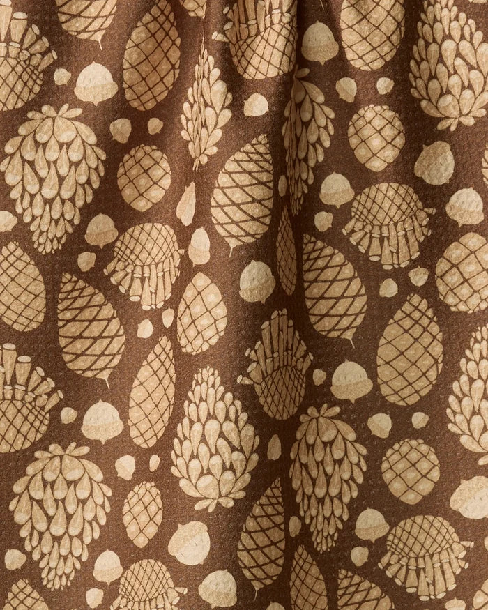 Golden Pines by Danelys Sidron features brown fabric with tan pinecones and dots for a forest-inspired look. This recycled, gathered kitchen towel is both eco-friendly and stylish for your space.