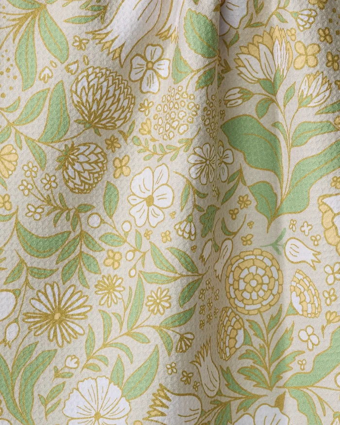 The "Golden Summer" tea towel by Danelys Sidron features a vintage-inspired yellow, green, and white floral pattern. Ultra-absorbent and decorative, it's the perfect botanical accent for everyday use in your kitchen.