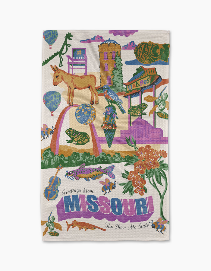 Geometry’s "Greetings From Missouri" tea towel features a vibrant, quick-drying illustration of Missouri landmarks, wildlife, and flowers, with “Greetings from Missouri The Show Me State” boldly displayed at the bottom.