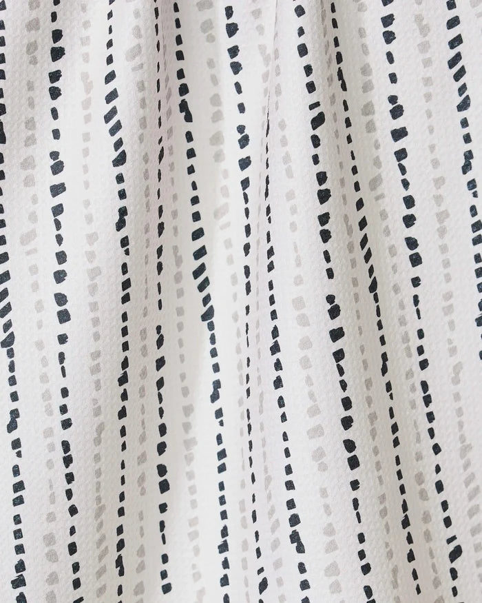 The GEOMETRY Grey Prints recycled kitchen towel features a simple, modern look with white fabric and vertical dotted lines in black and light gray, creating a textured and dynamic appearance.