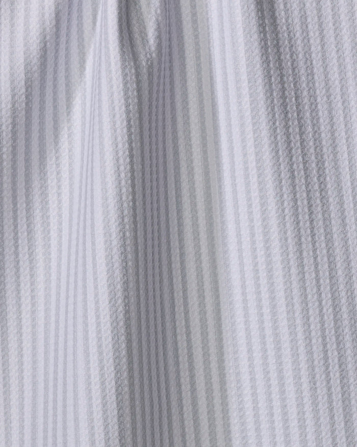 Close-up of the Kailee Wright Grey Salt towel, quick-drying with vertical textured stripes, gentle draping, and soft folds in white fabric highlighted by subtle shadows.
