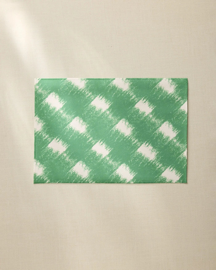 The Hairy Check Green placemat by Geometry features a white brushed checkered pattern on green, shown on a beige surface. Made from recycled materials, this everyday placemat is easy to clean and perfect for daily use.