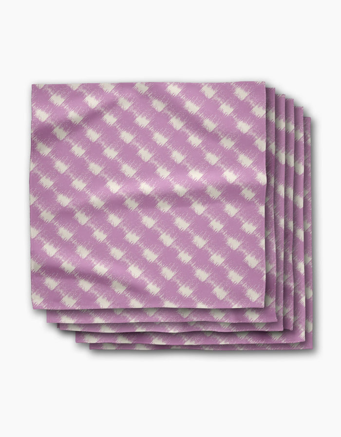 A stack of four Geometry Hairy Check Pink dinner napkins, featuring a white diagonal checkered pattern on Geosuede fabric, is displayed on a white background.