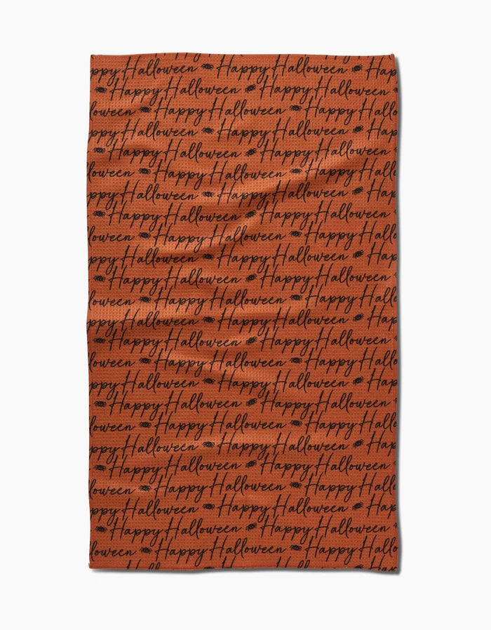 The Geometry Halloween Script Orange tea towel features rows of black cursive happy halloween on bright orange fabric, perfect for adding festive flair to your kitchen.