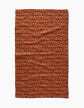 The Geometry Halloween Script Orange tea towel features rows of black cursive happy halloween on bright orange fabric, perfect for adding festive flair to your kitchen.