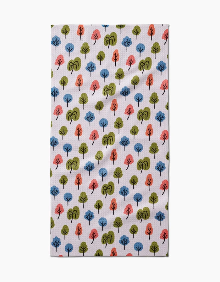 The Kayla Ann Happy Trees Bar Towel features a repeating pattern of small, stylized blue, green, and orange trees on white Geoweave fabric.
