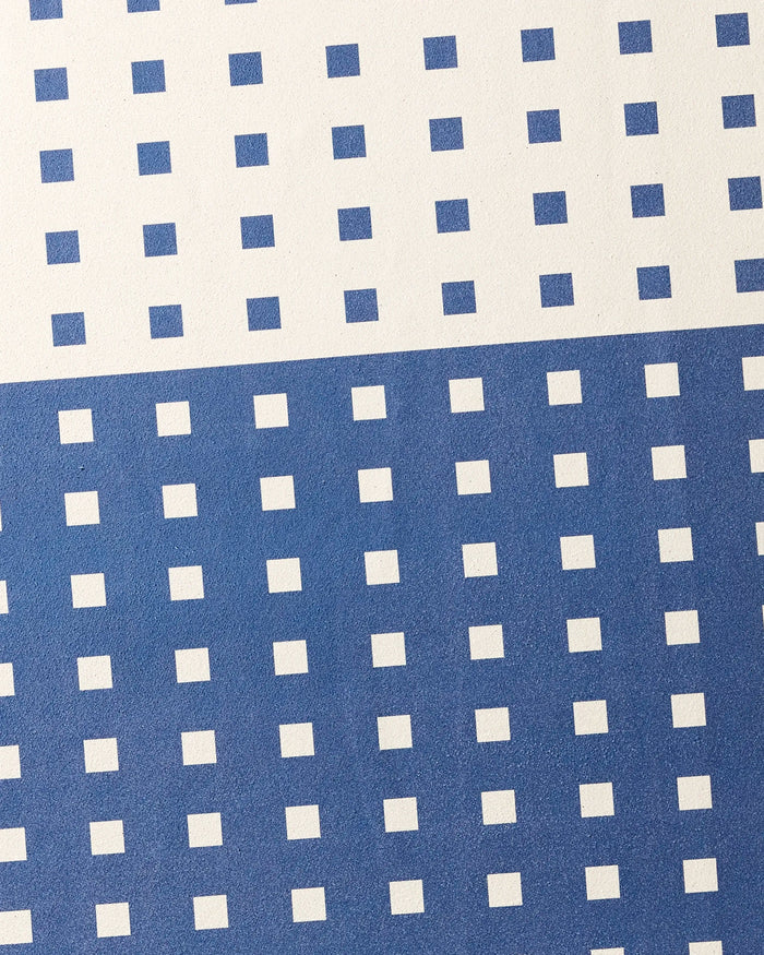 Harmony Haze by Happy Hemera features evenly spaced blue squares on white, with a white top half and a blue lower half accented by white squares—perfect for a stylish, non-slip yoga towel.