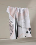 The Kailee Wright Harper Abstract dish towel, featuring absorbent white fabric with pastel pink, black, and gray shapes and lines, hangs on a string against a neutral background.