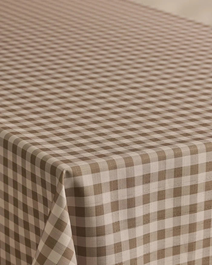 The Geometry Hazel Gingham tablecloth features a stain-resistant brown and white gingham pattern with evenly spaced diagonal checks, perfect for covering your rectangular table.