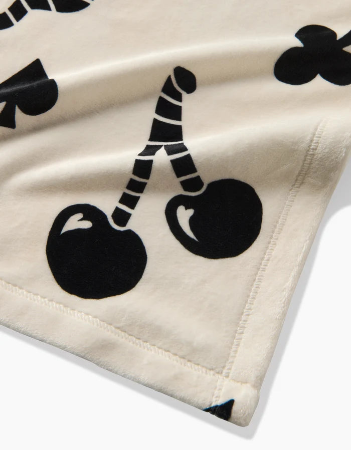 A close-up of Geometry's Heart Locket blanket in cream, showcasing black graphic heart and locket prints with detailed edging—crafted for cozy comfort and ideal among recycled blankets.