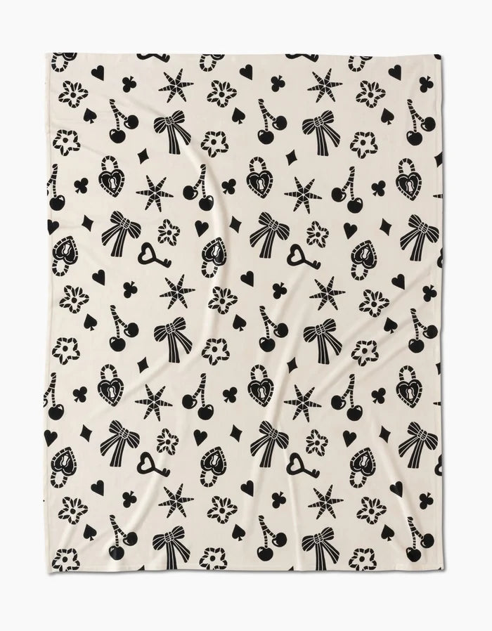 The Heart Locket by Geometry features a playful cream design with black bows, cherries, and hearts—crafted from recycled materials for silky-soft comfort youll love to snuggle into.