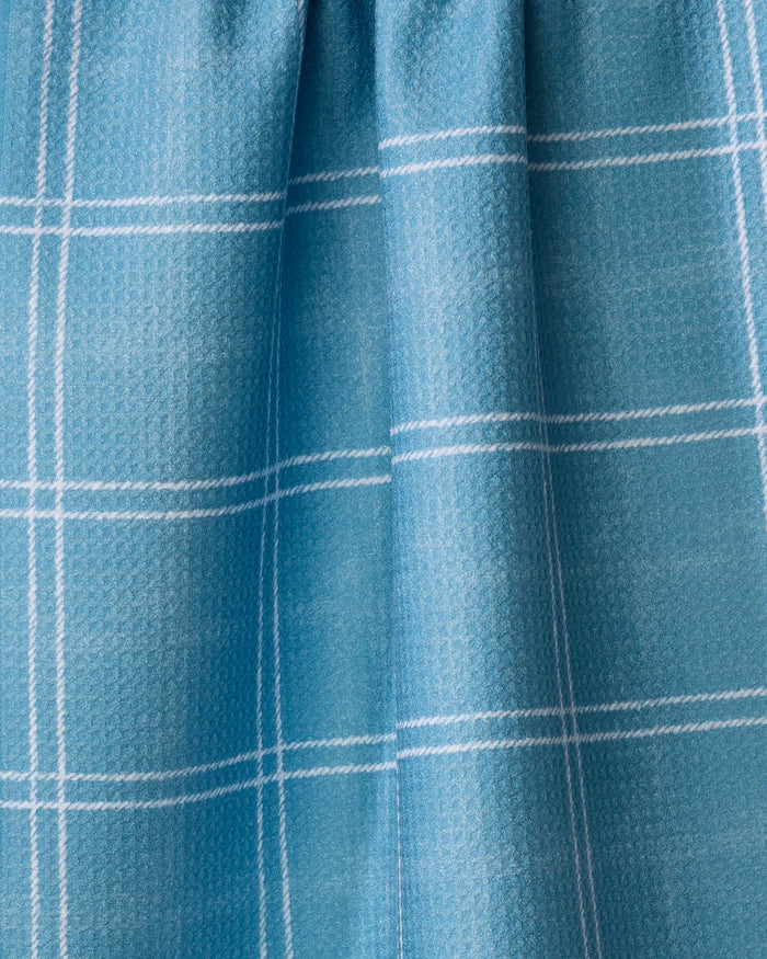 Close-up of the Geometry Hearth Bay towel, featuring ultra-absorbent light blue fabric with a white plaid pattern and soft vertical folds.