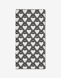 The Heartthrob Onyx bar towel by Charlie Rowan Designs is made from Geoweave fabric and showcases bold, high-contrast white hearts with radiating lines on a black background for a striking geometric look.