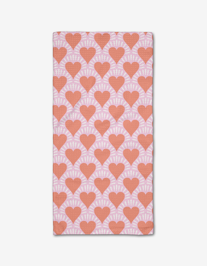 The Heartthrob bar towel by Charlie Rowan Designs features a light pink Geoweave fabric with evenly spaced red hearts outlined in white rays, creating a bold all-over pattern.
