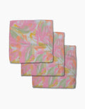 Three pastel-colored Geometry Heat Wave Geoweave dishcloths, featuring a floral-like pattern in pink, yellow, and green, are stacked on a white background. This super-absorbent set makes kitchen cleanup effortless.