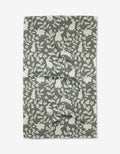 The Hippity Hop tea towel by Charlie Rowan Designs features a repeating pattern of white rabbits, leaves, and flowers in green and white on slightly wrinkled recycled fabric, laid flat on a white background.