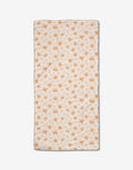 The Honey Bee Bar Towel by Kayla Ann is rectangular and white, featuring an orange floral and leaf pattern with neatly stitched edges, displayed flat on a white background.