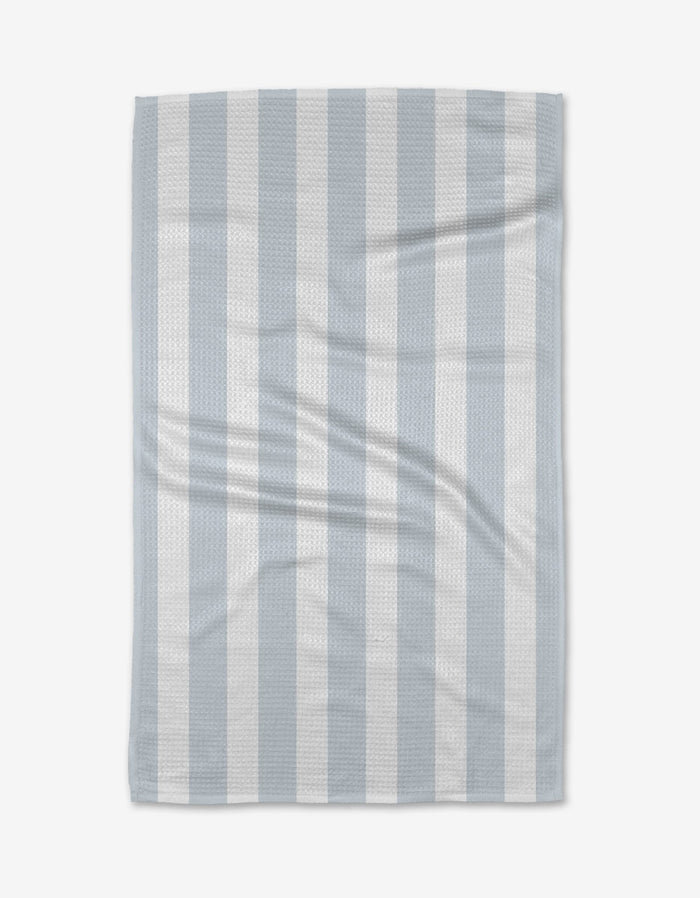 The BetterDays Hormones Tea Towel, featuring light blue and white vertical stripes with a waffle texture, is laid flat on a white background. Made from Geoweave™ fabric, it displays a slight wrinkle for added texture.
