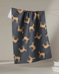 The "Horses" tea towel by Coit Creative, featuring a repeating tan horse pattern, hangs above white plates against a neutral background.