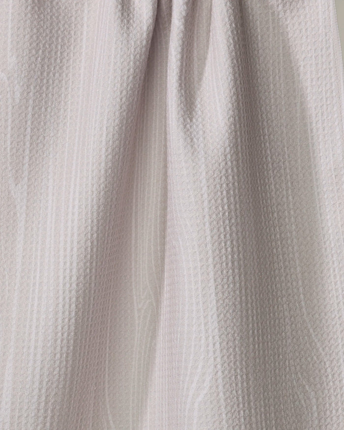 Close-up of the Houston Wood tea towel by Kailee Wright, in light beige, quick-drying, made from recycled materials with a subtle wavy pattern and soft draping folds.