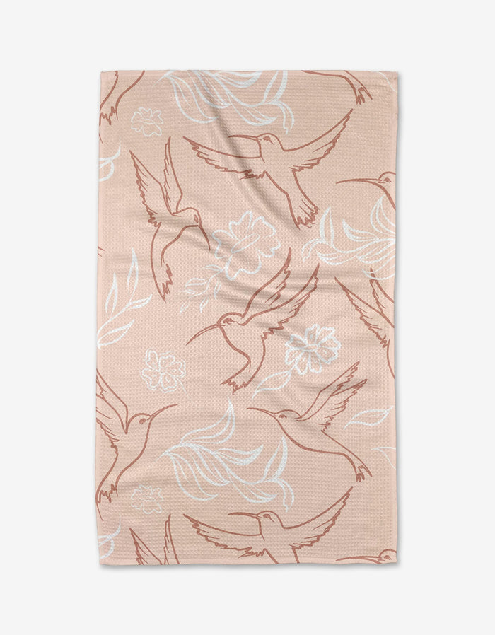 The Elena Fay Hummingbirds tea towel is light brown, made from recycled materials, and features outlined hummingbirds and floral patterns in white and reddish-brown for a charming, eco-friendly touch.