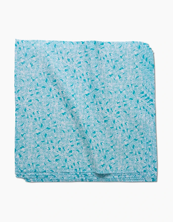 A neatly folded GEOMETRY Hydrangea square in light blue Geosuede, featuring a white leaf pattern, displayed on a plain white background.