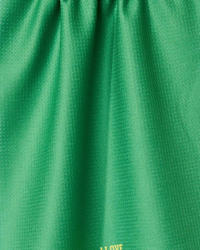 Close-up of a green, textured I Love Pickleball tea towel by GEOMETRY. Made from recycled materials, it has soft folds, a subtle sheen, and yellow text partially visible near the bottom edge.