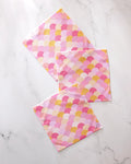 The GEOMETRY Inherit dishcloth set includes three super-absorbent towels in pink, yellow, and white scallop patterns, artfully displayed on a white marble surface.