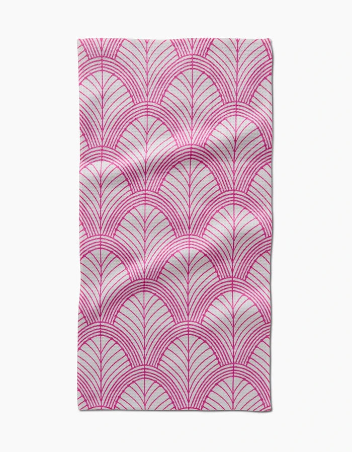 The Jaskin Bar Towel by Amy MacCready features rectangular Geoweave fabric with a pink fan-like geometric pattern on white, accented by thin radiating lines. Slight creases and folds are visible.