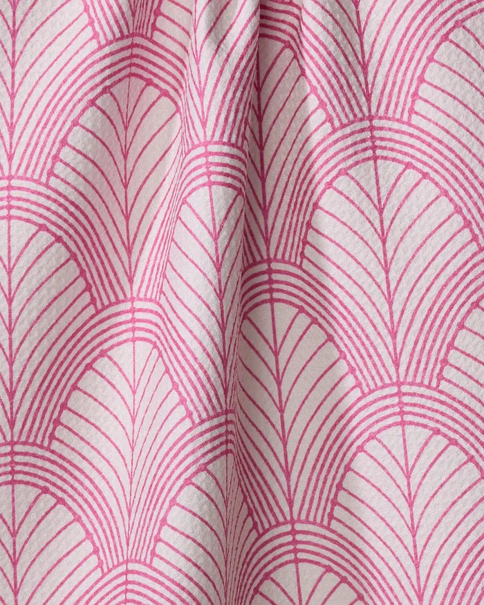 Close-up of Amy MacCready’s Jaskin eco-friendly kitchen towel, featuring a pink and white geometric fan pattern and slightly pleated absorbent fabric.