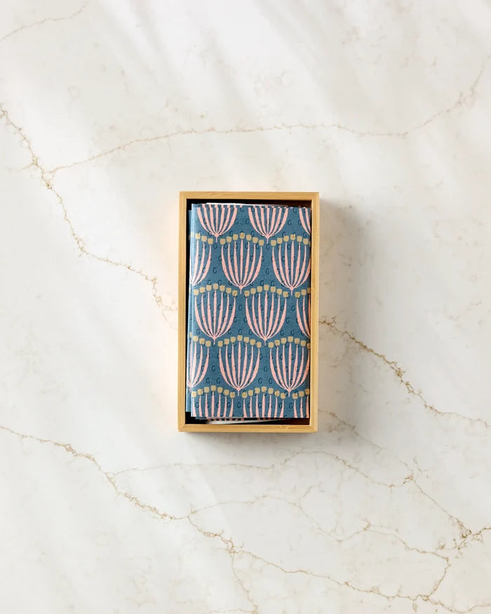 A small rectangular Josie box by Amy MacCready contains cards with a blue background and pink and white abstract floral patterns, reminiscent of reusable paper towels, displayed on a light marble surface.