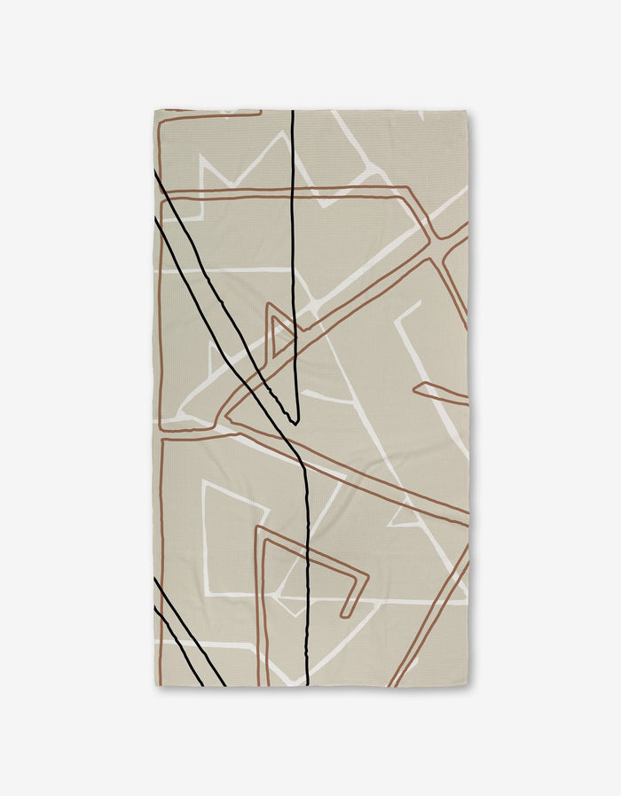The GEOMETRY Journey rug features a rectangular beige design with abstract, overlapping lines in black, brown, and white on a plain background—crafted from recycled materials for an eco-friendly touch.