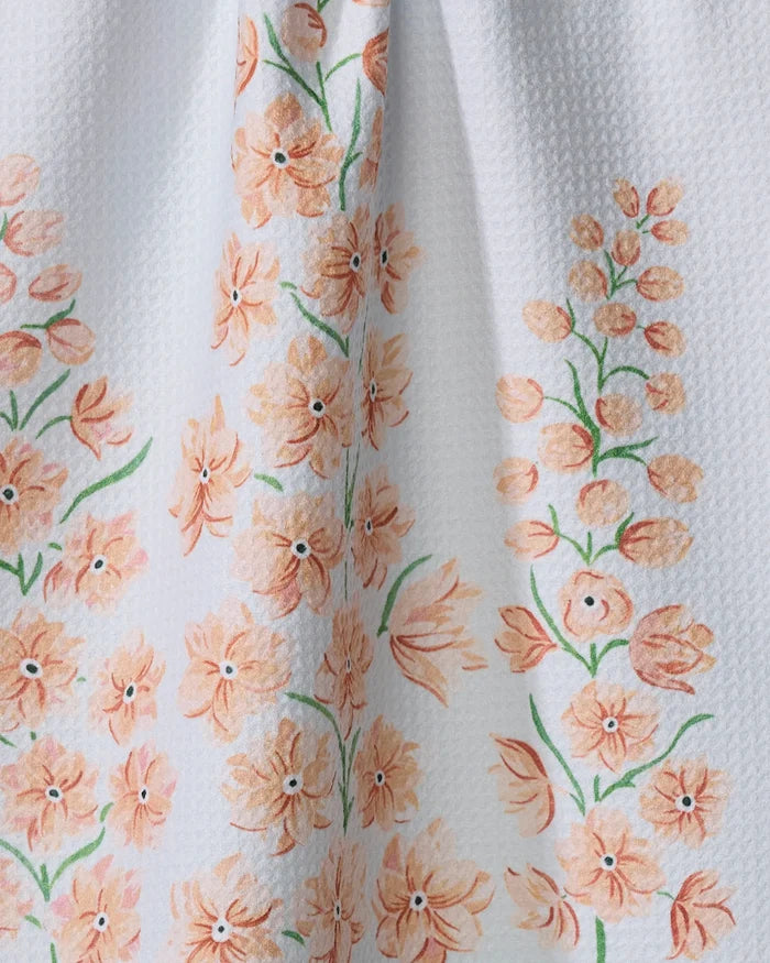 The July Delphinium by Linda Fox is a textured white recycled kitchen towel with orange and peach flowers and green stems in vertical clusters.