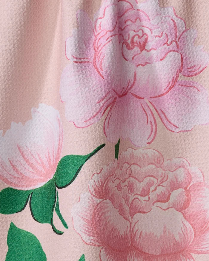 Close-up of Linda Fox’s June Roses fabric: quick-drying material with a textured surface, decorated with large pink peony flowers and green leaves on a light pink background.