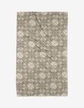 The Ash Cascade Kaleidoscope rug features a symmetrical geometric design with green and beige diamond and cross shapes, crafted from ultra-absorbent Geoweave™ fabric for kitchen tea towel-like durability.