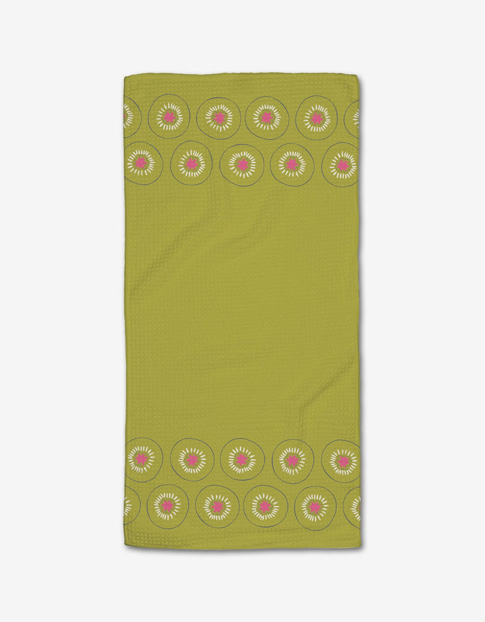 The Kiwi Kraze Bar Towel by Lizzie Clark features Geoweave fabric and a plain green center, with green, white, and pink kiwi slice borders along the top and bottom edges.