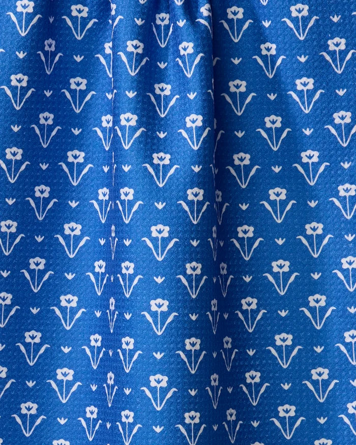 Close-up of Ladylake - Navy by The Buy Guide, a blue fabric with small white floral patterns. Made from recycled materials, it has a gentle gather at the top for soft vertical folds and subtle shadows.