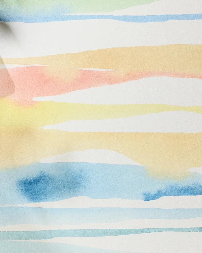 Lakeside by Sara Mari features abstract watercolor stripes in blue, yellow, and peach on white. The gentle design evokes calm, reminiscent of a recycled yoga towel’s soothing effect.