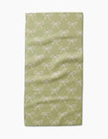 The Laura Prietto Lattice Bows bar towel is light green, made with ultra-absorbent textured Geoweave fabric, and features a repeating pattern of white bows.